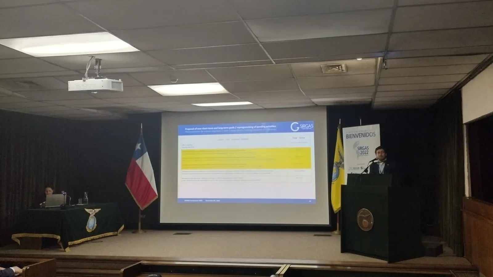 Dr. Demián Gómez presenting during the 2022 SIRGAS symposium. A projected screen shows an image of findings
