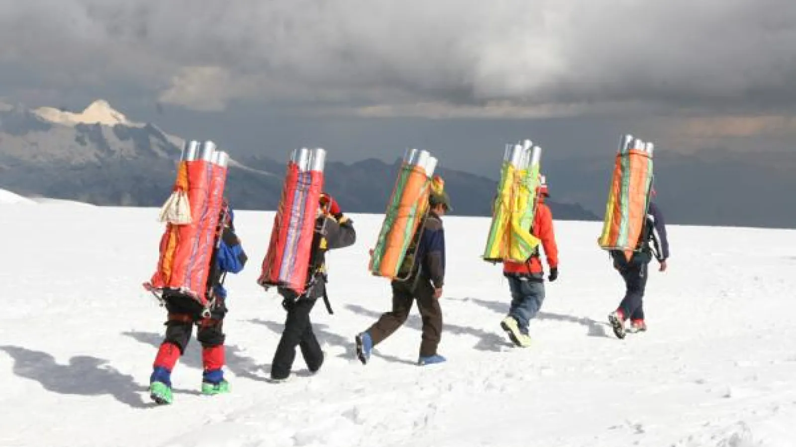Porters must carry the ice cores down from the drill site after the drilling is finished. (Credit: Lonnie Thompson)