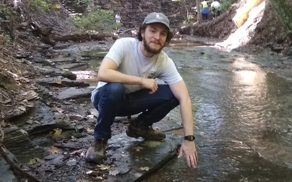 Adolfo Calero kneeling in a riverbed