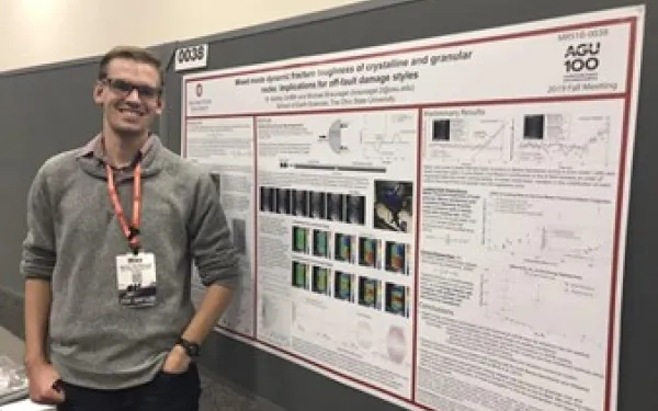 Man in front of poster