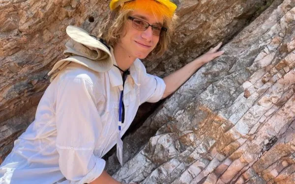 Brandon Bell in Italy leaning on an outcrop