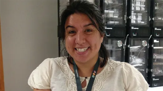 Kathy Ann Hollis smiling in front of collections in the Smithsonian