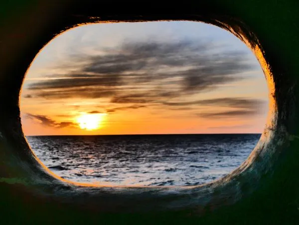A beautiful view of sunrise over the sea through the hawsehole. (Credit: Natacha Fabregas & IODP JRSO)